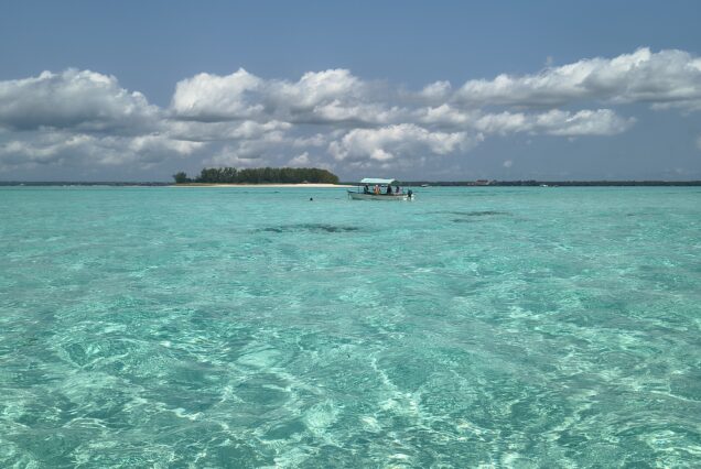 Turquoise waters with boat near Mnemba Island, Zanzibar.