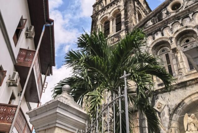 Historic church in Stone Town Zanzibar with palm trees and blue sky.